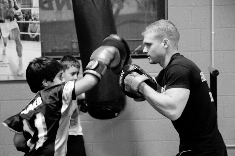 Coach training a young boxer